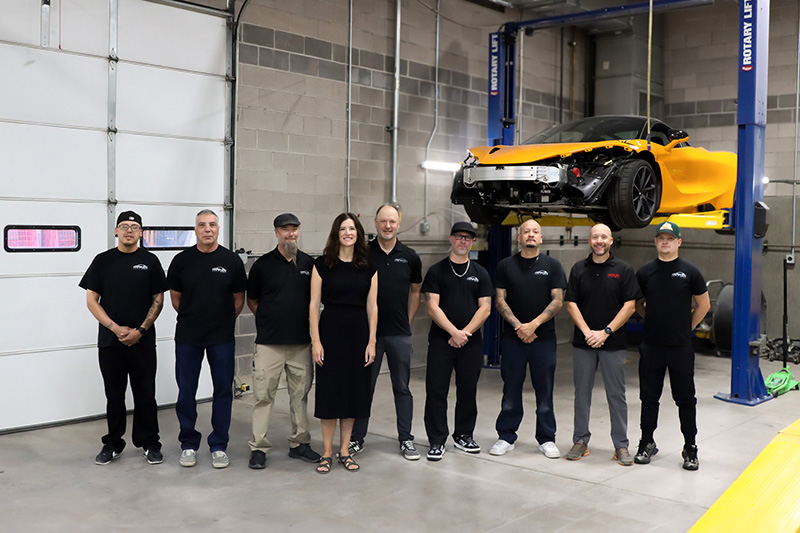 Hampden Auto Body friendly staff in front of a Mclaren Hampden Auto Body friendly staff in front of a Mclaren